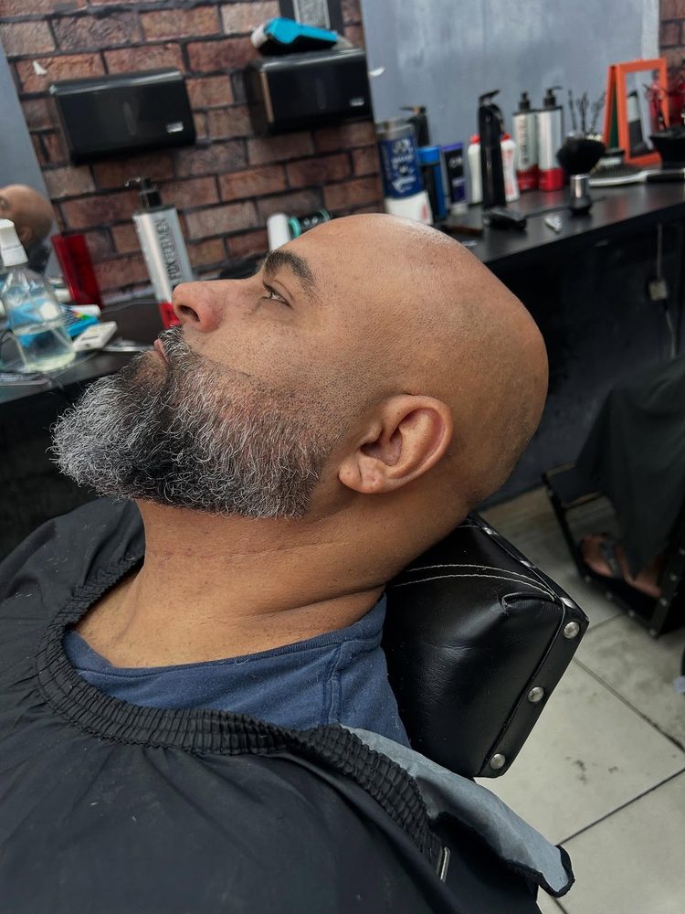 Cliente com barba aparada e acabamento na cadeira